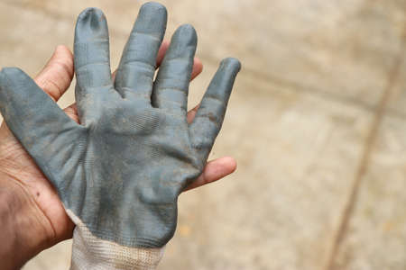Working gloves held in hand after garden works with clean hands underneath. Protective gloves to safeguard hands on work processの写真素材