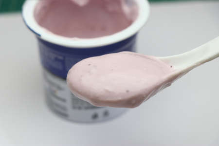 Blueberry flavored yoghurt in a spoon, Small cup of yogurt which is sour food perfect for desserts