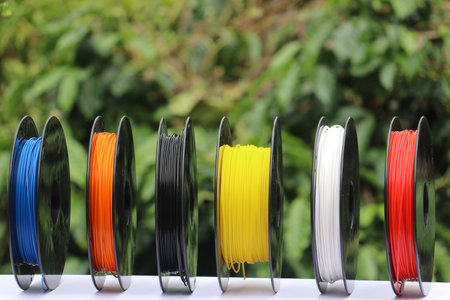 3D printer filaments on a spool isolated on nature background showing the concept of biodegradable...