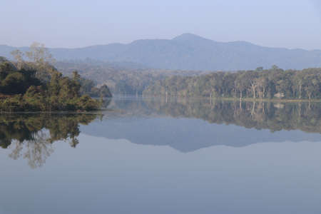 Fresh Morning with misty sky and view of Mountains and forest reflections on the lake waterの写真素材