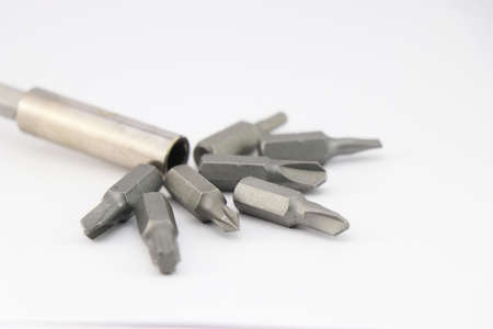 Drill bits of various shapes along with screwdriver head on white background