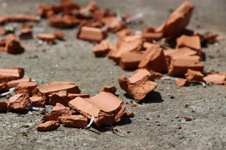 Broken roof tiles in pieces spread on the ground with natural outdoor light