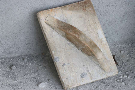 Wooden trowel used for planing concrete surface after plastering. The old way of construction using...