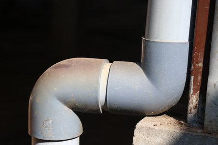The joins of a PVC pipe used in plumbing to carry water from roof to the ground exposed with...