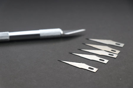 Hobby knife also called as crafting knife with spare blades isolated on black background