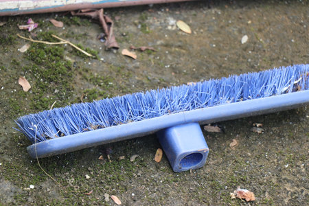 Old and abandoned floor cleaning brush made of plastic laying on the ground. Concept of plastic pollution and recyclingの写真素材