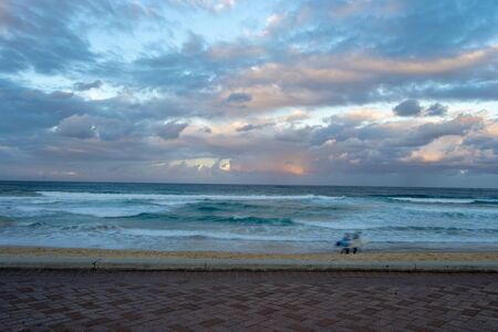 Manly beach beautiful sunset with a rainbow surfers on the beachの写真素材