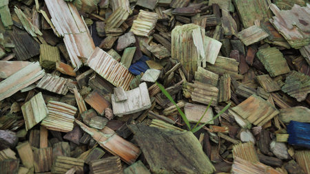 A chaotic assortment of broken ceramic tiles, concrete, and construction debris in various colors like green, blue, and brown, scattered on the ground.の写真素材