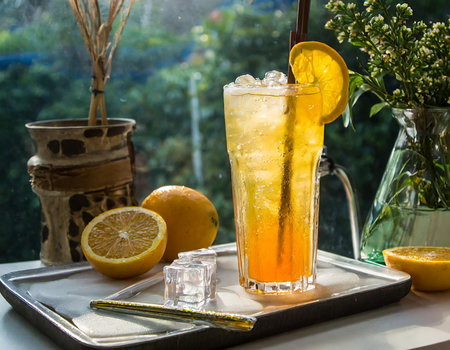 Iced tea with lemon and ice cubes on a window sill.の素材