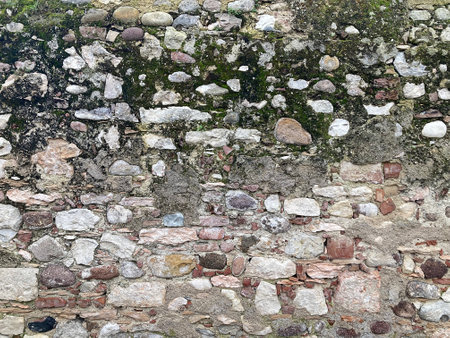 Old brick wall with moss and pebbles. Background texture.の写真素材