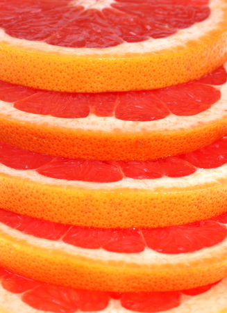 Cut grapefruit slice on whiteの写真素材