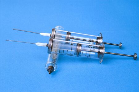 Glass Syringes with needle , over blue backgroundの写真素材