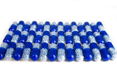 A lot of blue capsule  medicine on the white backgroundの写真素材