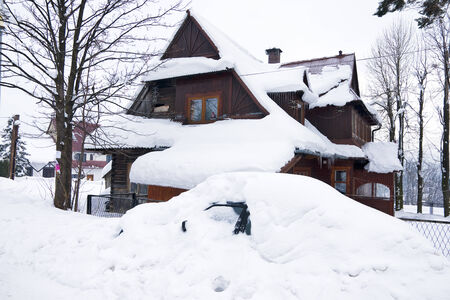 House and car under snow in the mountain village Polishの写真素材