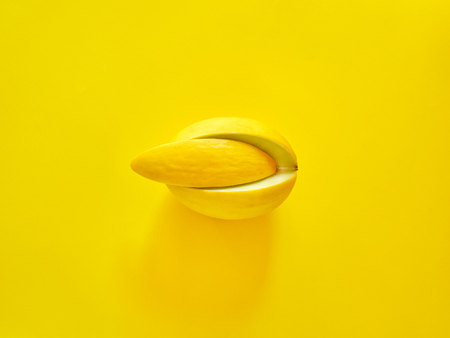 Yellow Melon Fruit isolated in yellow background viewed from above - flatlay look - Image Minimalism conceptの写真素材