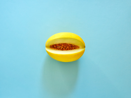 Yellow Melon Fruit isolated in cyan background viewed from above - flatlay look - Image Minimalism conceptの写真素材