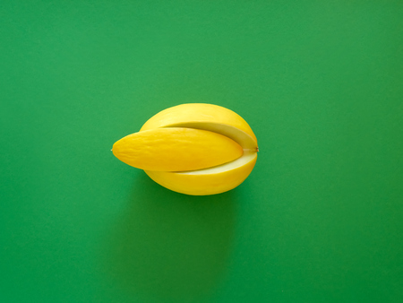 Yellow Melon Fruit isolated in green background viewed from above - flatlay look - Image Minimalism conceptの写真素材