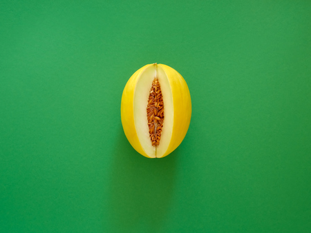 Yellow Melon Fruit isolated in green background viewed from above - flatlay look - Image Minimalism conceptの写真素材