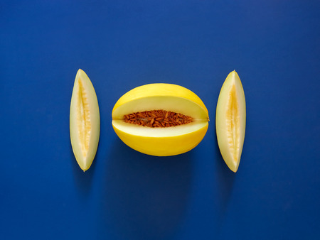Yellow Melon Fruit isolated in blue background viewed from above - flatlay look - Image Minimalism conceptの写真素材