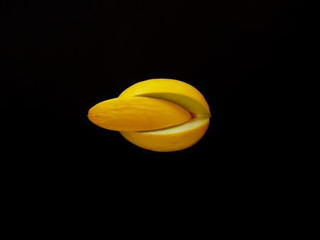 Yellow Melon Fruit isolated in black background viewed from above - flatlay look - Image Minimalism conceptの写真素材
