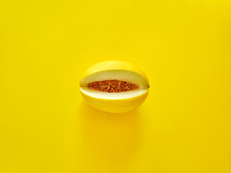 Yellow Melon Fruit isolated in yellow background viewed from above - flatlay look - Image Minimalism conceptの写真素材