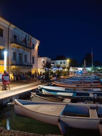 Small fishing boats anchored in the marina of the town of Bardolino on the shores of Lake Garda Late at nightのeditorial素材