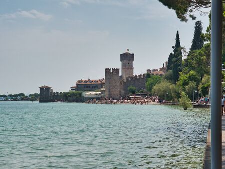 View of the Scaligero Castle and its adjacent public beach from the panoramic promenade of Sirmione village on the shores of Lake Garda, Italyのeditorial素材