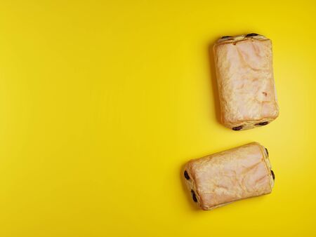 Chocolate Croissants or Chocolate Breads over a yellow background - 3d Computer Renderingの写真素材