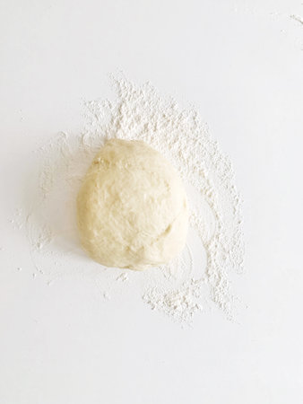 Bun of wheat flour over a white table ready for cookingの写真素材