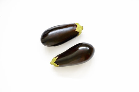 Pair of eggplants isolated in white background viewed from above - flatlay lookの写真素材