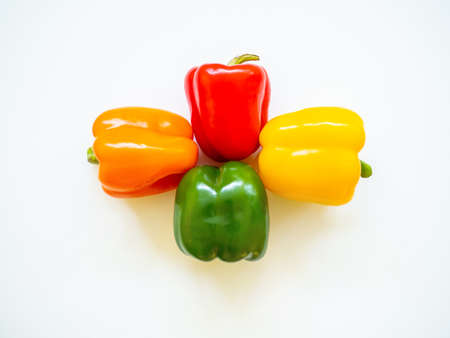 Group of red, green, yellow, and orange bell peppers isolated in white background in studioの写真素材