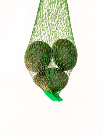 Avocados in a green net  isolated and suspended on air with a white background in studio background in studioの写真素材