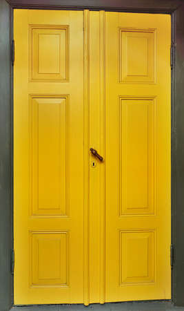 Yellow door with dark green wooden frameの写真素材