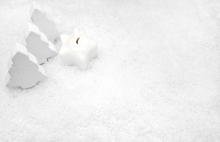 White candle and fir trees in the snowの写真素材