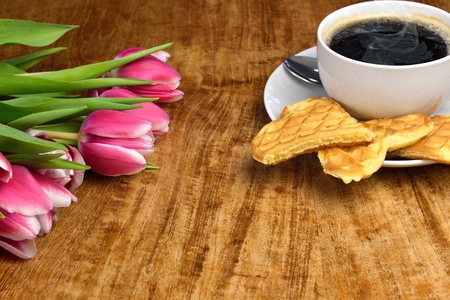 Fresh tulips, a cup of hot, steaming coffee and freshly baked wafflesの写真素材
