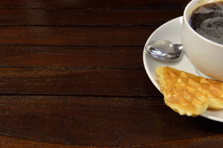 Cup of steaming coffee and a fresh waffleの写真素材