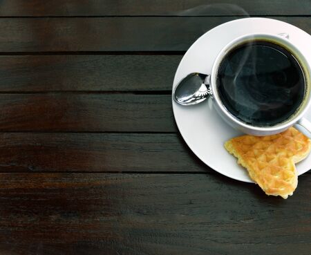 Cup of steaming coffee and a fresh waffleの写真素材