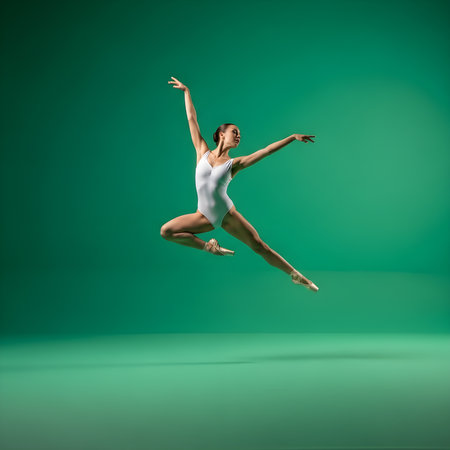 A professional female ballet dancer performs an elegant mid-air jump, showcasing exceptional strength, flexibility, and artistic grace. Dressed in a white leotard and pointe shoes, she moves dynamically against a vibrant green studio background. This captivating image highlights the beauty and discipline of classical ballet, perfect for projects related toの素材