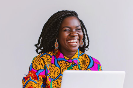 Portrait of a happy young African woman using laptop computer.の素材