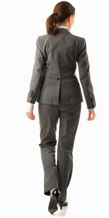 back view of a young business woman in suit walking on white backgroundの素材