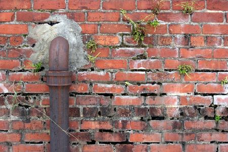 Closeup rusted metal pipe on brick wall.の写真素材