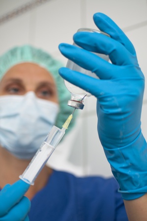 masked nurse aspirating an infusionの写真素材