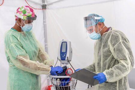 Healthcare providers test for CoVid19 and discuss antidote and testing in sterile make shift tent...