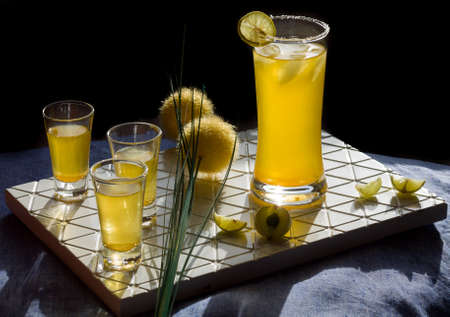 Fresh,sweet,healthy yellow berries and lime mocktail garnished with saffron,lime zest,ice is...