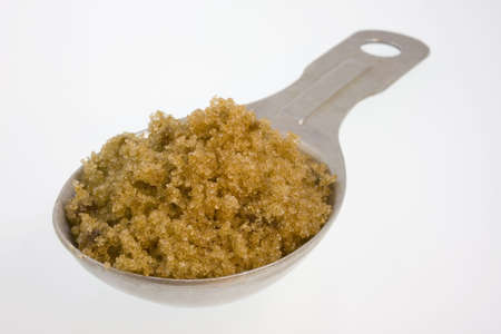Tablesoon of brown sugar on whiteの写真素材