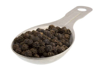 Measuring tablespoon of black peppercorns isolated on white, 