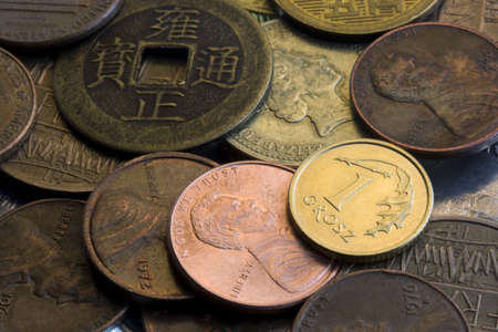 background of coins with Polish grosz, USA penny and vintage Japanese one in front
