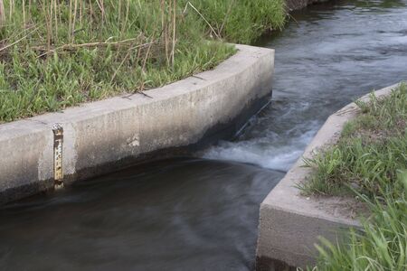 irrigation ditch with a flow measurement concrete structure and water scale, Coloradoの写真素材
