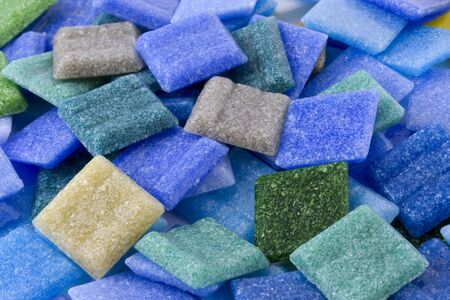 a pile of frosty glass small square mosaic tiles with  blue and green dominant color