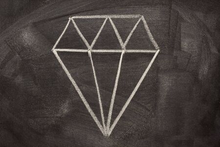 A modern, pictorial sign for crystal, depicting a common way of cutting diamonds. It is often used on jewellers. Rough sketch with white chalk on a blackboard.の写真素材